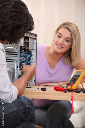 Photo: young man repairing a computer young man repairing a computer