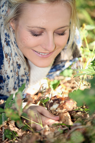 Photo: Smiling woman picking mushrooms Smiling woman picking mushrooms