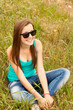 Foto: Beautiful teen girl in the park at green grass. Beautiful teen girl in the park at green grass.