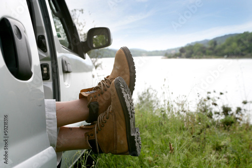 Photo: Man snoozing in car parked by lake Man snoozing in car parked by lake