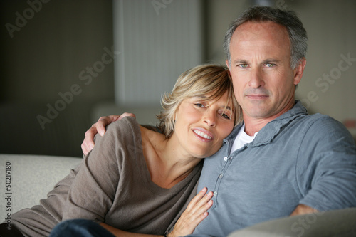 Photo: Affectionate married couple sat at home Affectionate married couple sat at home