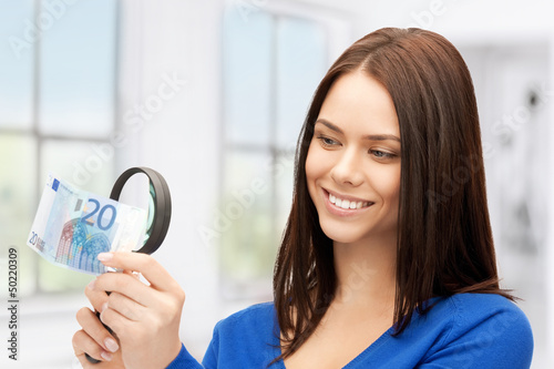 Photo: woman with magnifying glass and euro cash money woman with magnifying glass and euro cash money
