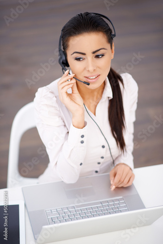 Photo: High angle shot of business woman sitting at the desk High angle shot of business woman sitting at the desk