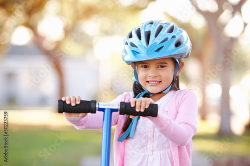 Photo: Girl Wearing Safety Helmet Riding Scooter Girl Wearing Safety Helmet Riding Scooter