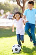 Two Children Playing Soccer Together