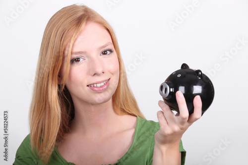 Photo: portrait of a young woman with money box portrait of a young woman with money box