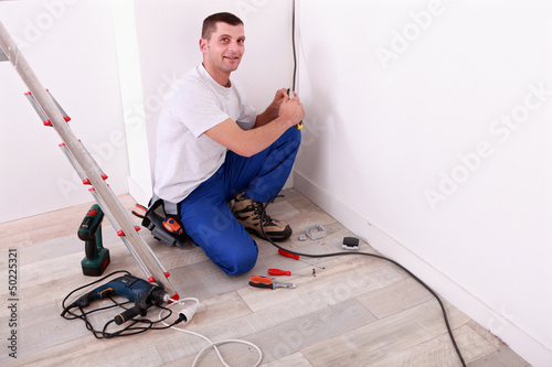 Photo: Tradesman installing electrical wiring Tradesman installing electrical wiring