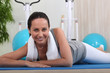 Brunette laying on floor in gym and cooling down