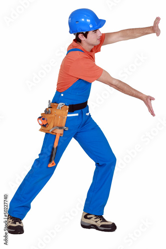 Photo: Tradesman pushing an invisible wall Tradesman pushing an invisible wall
