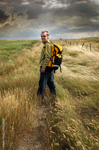 Photo: Man looking back and smiling on a country road Man looking back and smiling on a country road