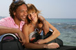 Young couple at the beach stood by convertible car