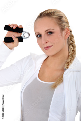 Photo: Woman using hand grippers at the gym Woman using hand grippers at the gym