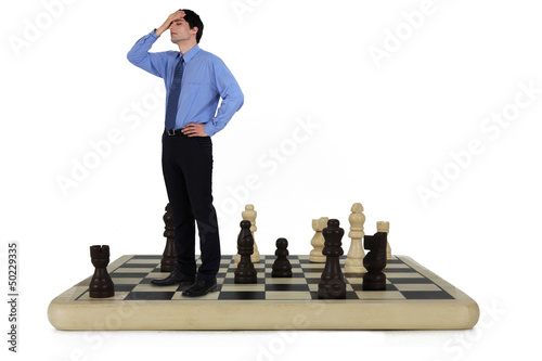 Photo: Man standing on a chess board Man standing on a chess board