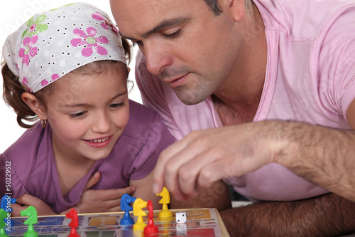 Photo: Father and daughter playing board game Father and daughter playing board game