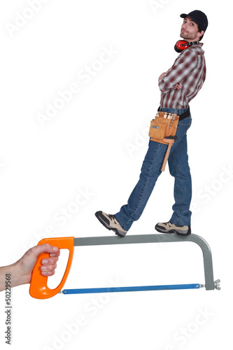 Photo: Worker standing on a saw Worker standing on a saw