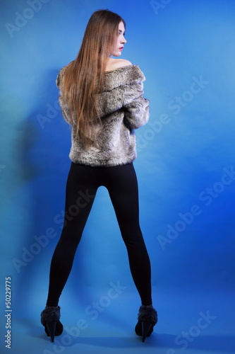 Photo: young woman in fur long hair blue background young woman in fur long hair blue background