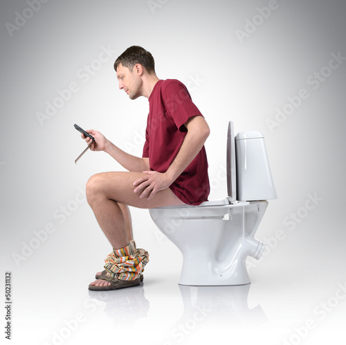 Photo: Man with mobile phone sitting on the toilet Man with mobile phone sitting on the toilet