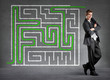 Businessman solved a maze on a wall