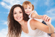 Foto: Happy mother and daughter playing on sky background Happy mother and daughter playing on sky background