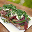 crostini mit schinken, gemüse, käse, pesto und rucola