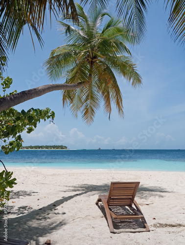 Photo: beach chair at ocean front under palm tree beach chair at ocean front under palm tree