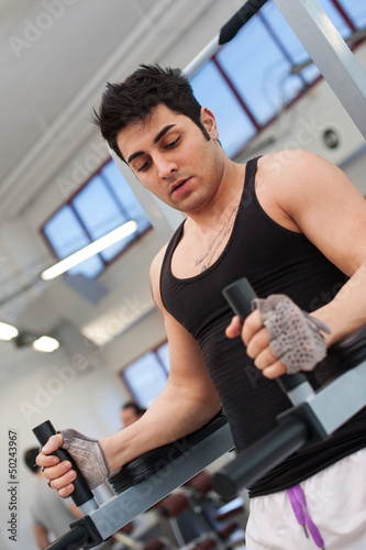 Photo: Young man training in the gym. Young man training in the gym.