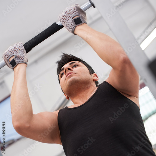 Photo: Young man training in the gym. Young man training in the gym.