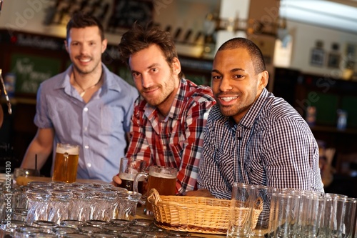 Photo: Young men drinking beer at bar counter Young men drinking beer at bar counter