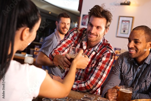 Photo: Man getting glass of beer from bartender Man getting glass of beer from bartender