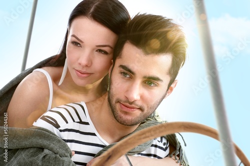 Photo: Loving couple embracing on sailing boat at summer Loving couple embracing on sailing boat at summer