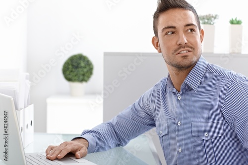 Photo: Portrait of young man with laptop Portrait of young man with laptop
