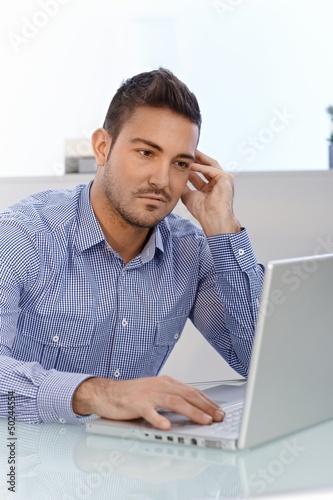 Photo: Young man lost in work Young man lost in work