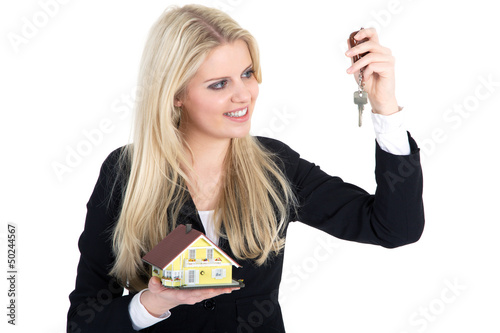 Photo: Junge blonde Frau freut sich über Schlüssel für Haus Junge blonde Frau freut sich über Schlüssel für Haus