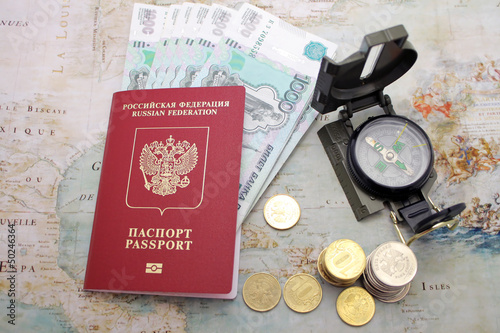 Photo: Passport, money and compass. background of the map of the world Passport, money and compass. background of the map of the world