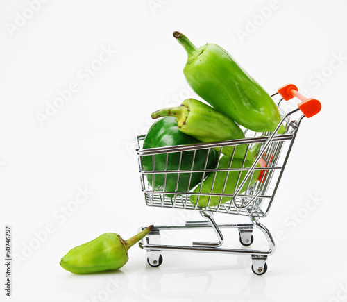 Photo: Green sweet pepper paprika in shopping trolley on white backgro Green sweet pepper paprika in shopping trolley on white backgro