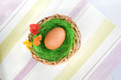 egg in a pottle with grass and flowers