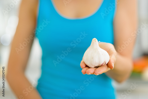 Photo: Closeup on garlic in hand of woman Closeup on garlic in hand of woman