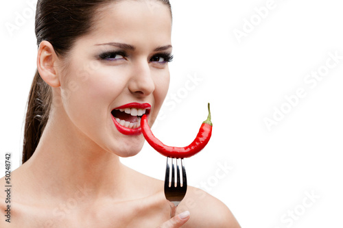 Photo: Woman with .hot pepper on fork, isolated on white Woman with .hot pepper on fork, isolated on white