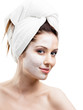 Woman in headband with cream applied on a half of her face