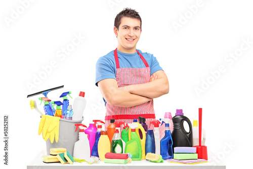 Photo: Young man in apron posing with cleaning supplies Young man in apron posing with cleaning supplies