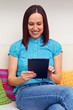 woman sitting on sofa and using her touch pad