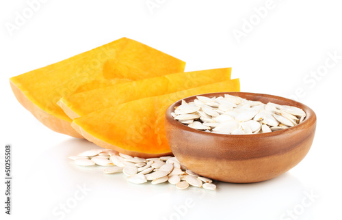 Photo: Pumpkin seeds in wooden bowl isolated on the white Pumpkin seeds in wooden bowl isolated on the white