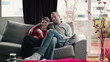 Happy couple watching tv at home