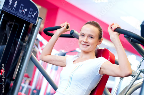 Photo: Woman doing splits on machine with weights Woman doing splits on machine with weights