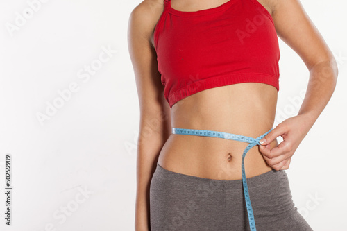 Photo: Woman measuring her waist Woman measuring her waist