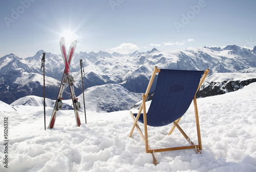 Photo: Cross ski and Empty sun-lounger at mountains in winter Cross ski and Empty sun-lounger at mountains in winter