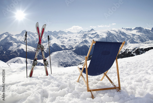 Photo: Cross ski and Empty sun-lounger at mountains in winter Cross ski and Empty sun-lounger at mountains in winter
