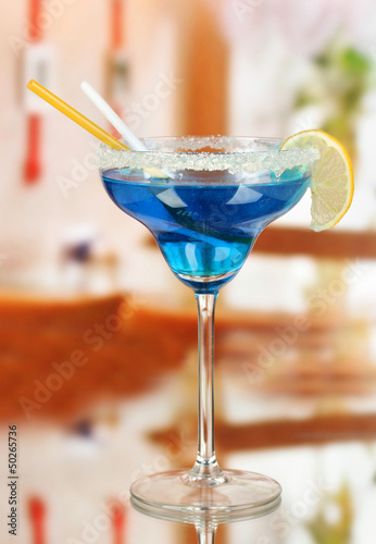 Photo: Blue cocktail in glass on room background Blue cocktail in glass on room background