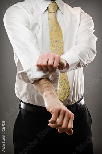 Photo: Business man rolling up sleeves Business man rolling up sleeves