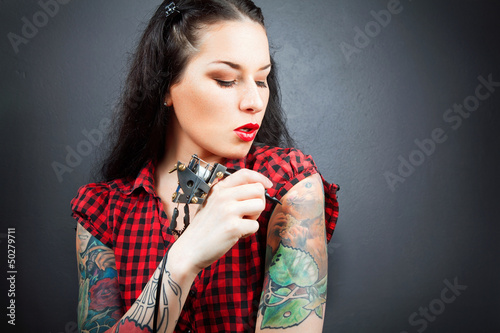Photo: Photo of beautiful girl with tattoos and tattoo machine. Photo of beautiful girl with tattoos and tattoo machine.